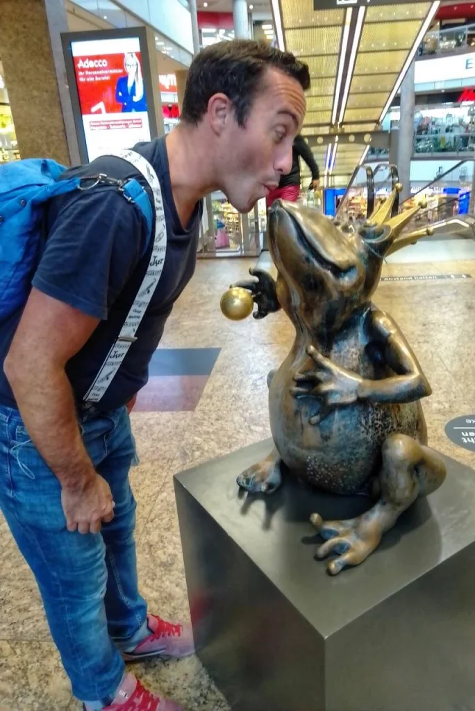 Floo begegnet einer Froschfigur mit neugierigem Blick